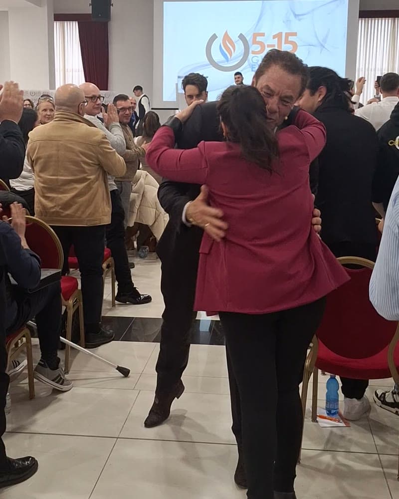 Tom Cummins embracing an attendee in the aisle after a seminar session