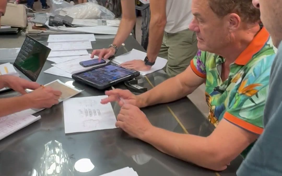 Tom Cummins reading a client document across a meeting table.