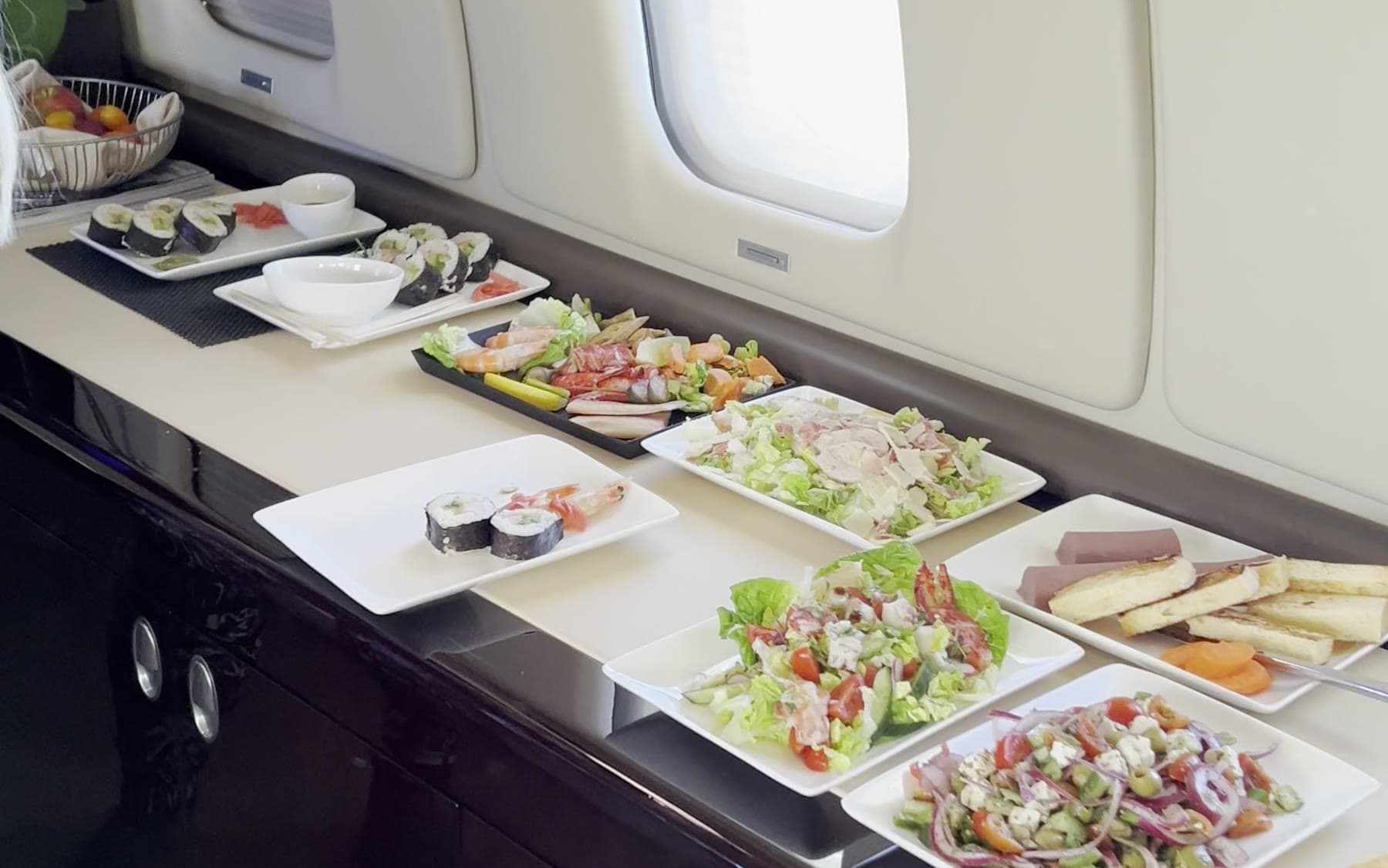 A fresh catering spread laid out along the sideboard of a private jet cabin.