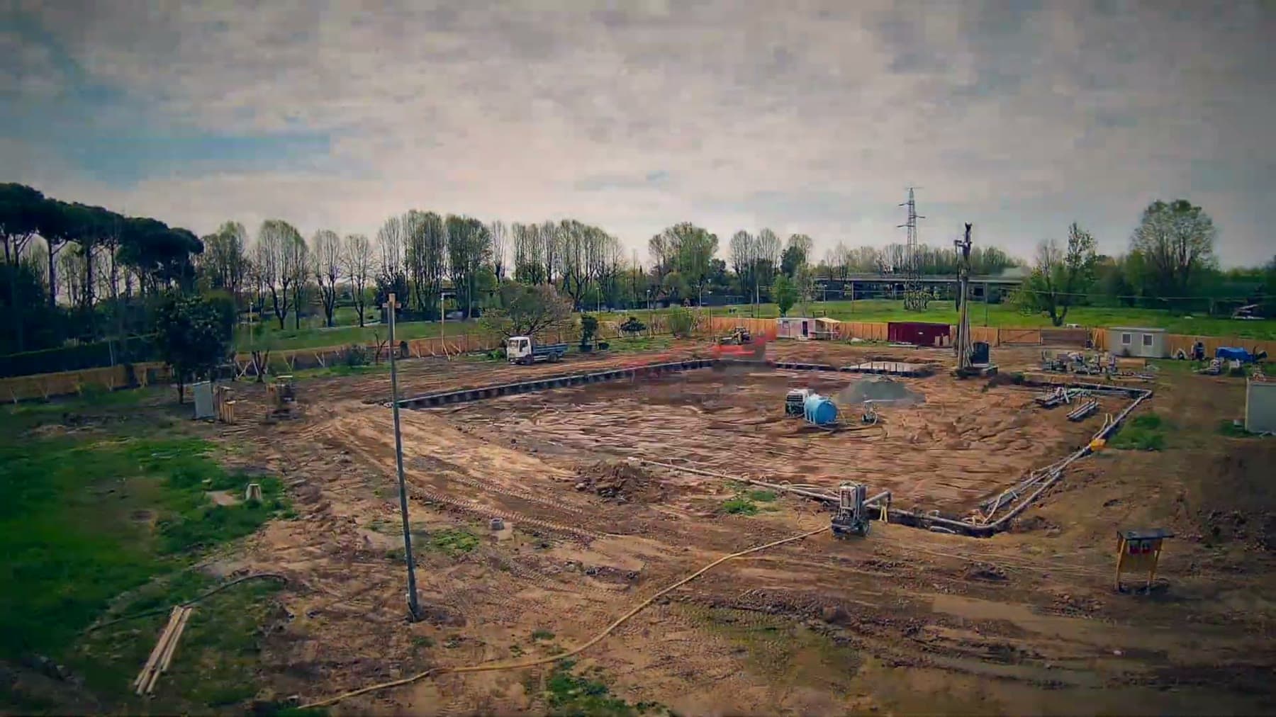 Bare graded ground and survey gear where Tom Cummins's build begins.