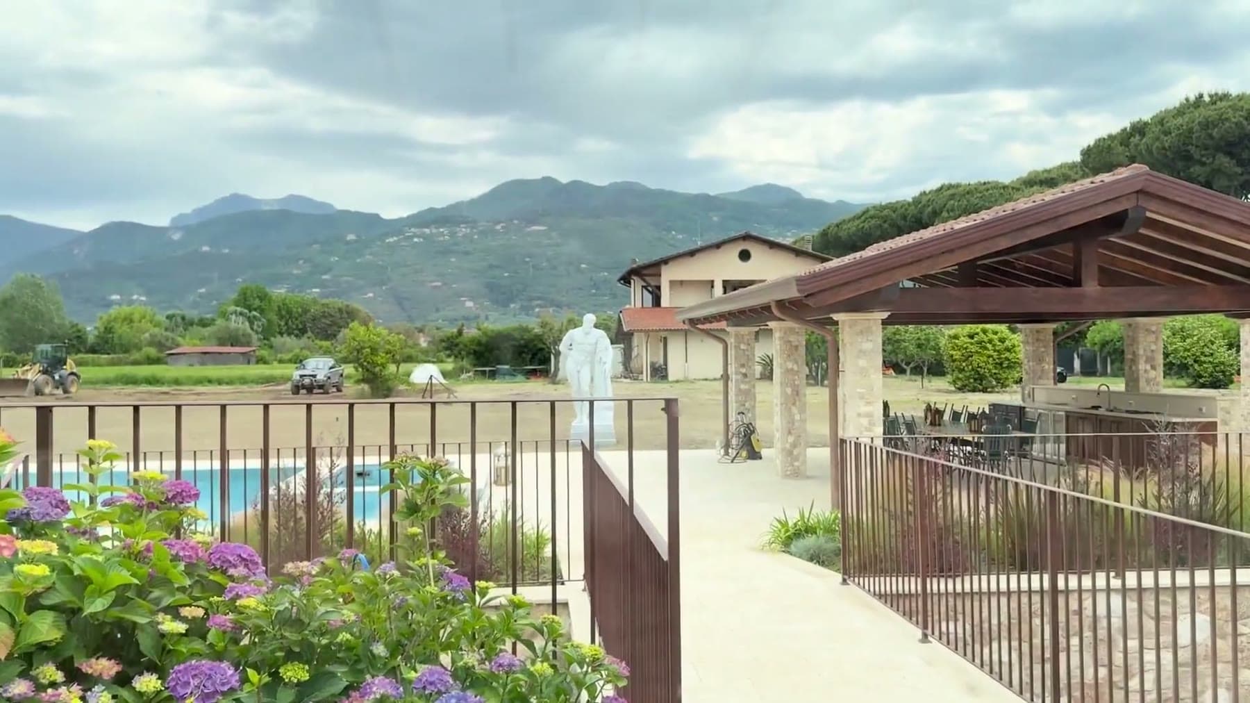 The pool and pergola of Tom Cummins estate in Tuscany with mountains behind.
