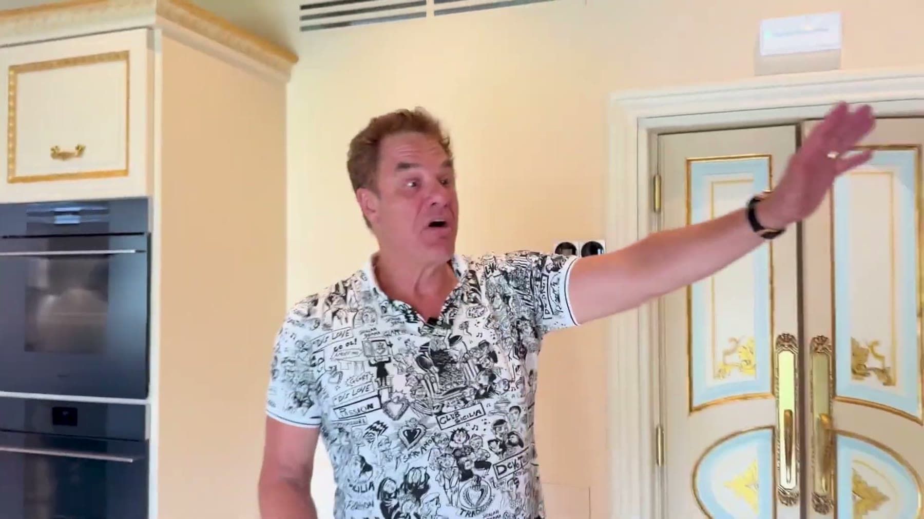 Tom Cummins presenting a set of ornate double doors at his villa.
