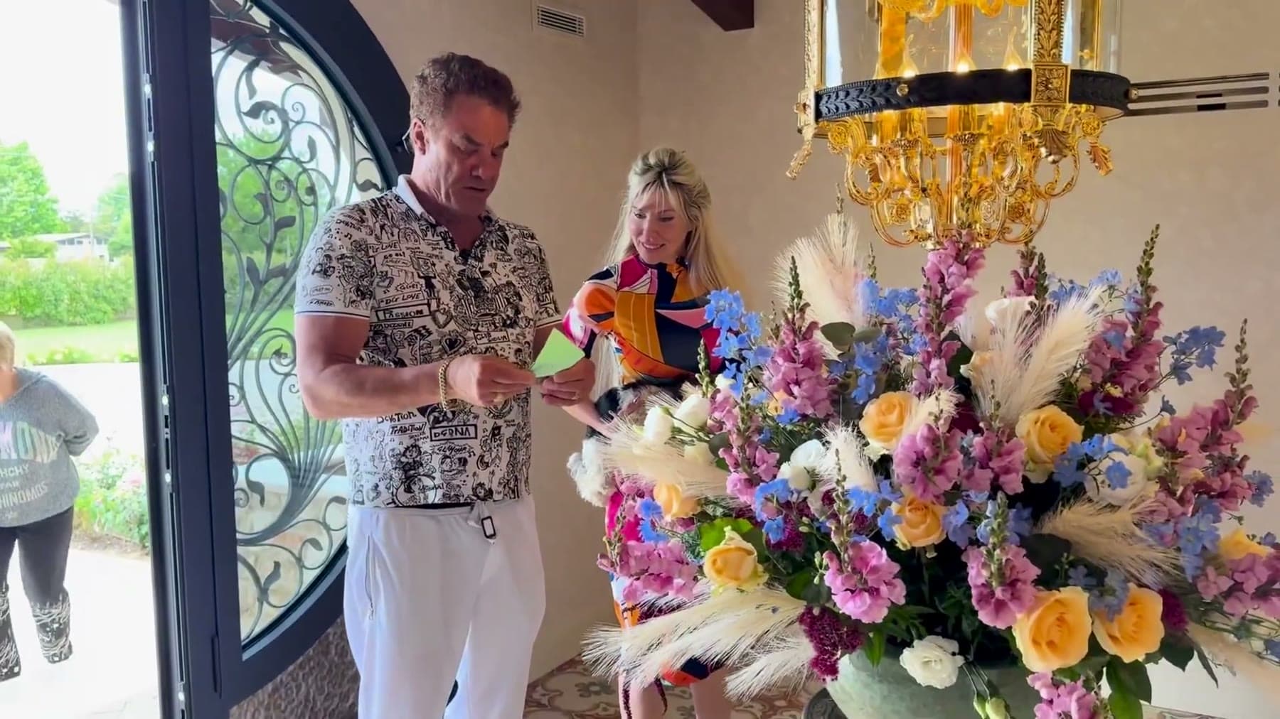 Tom Cummins with his partner in the villa entry hall beside fresh flowers.