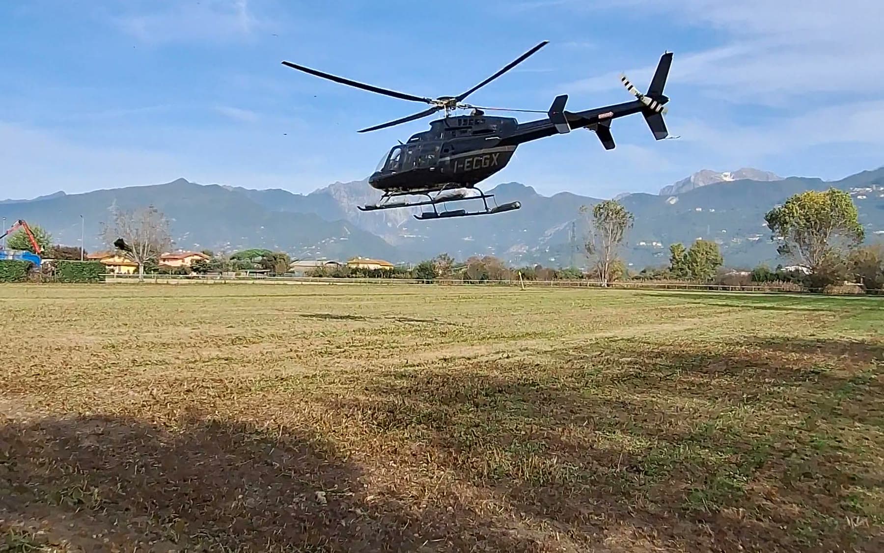 Tom Cummins's helicopter climbing away over the field into open sky.