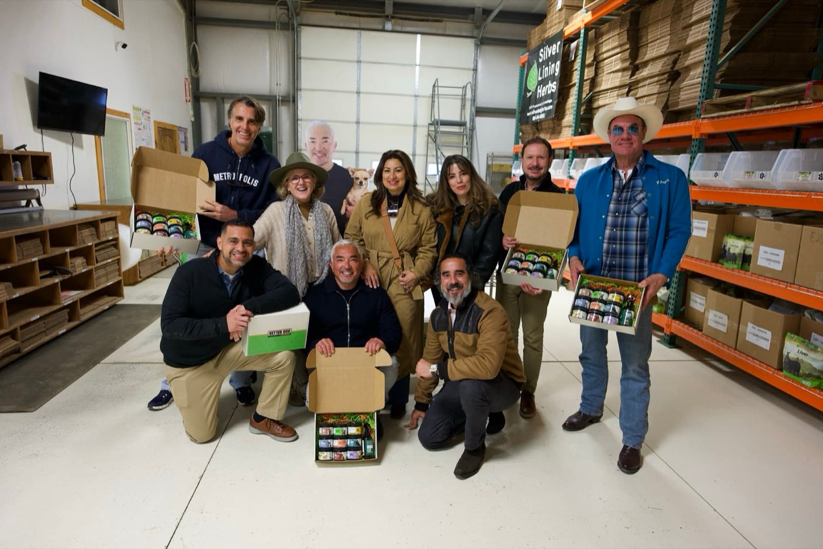 Tom Cummins with Cesar Millan and the Better Dog team, holding Better Dog boxes