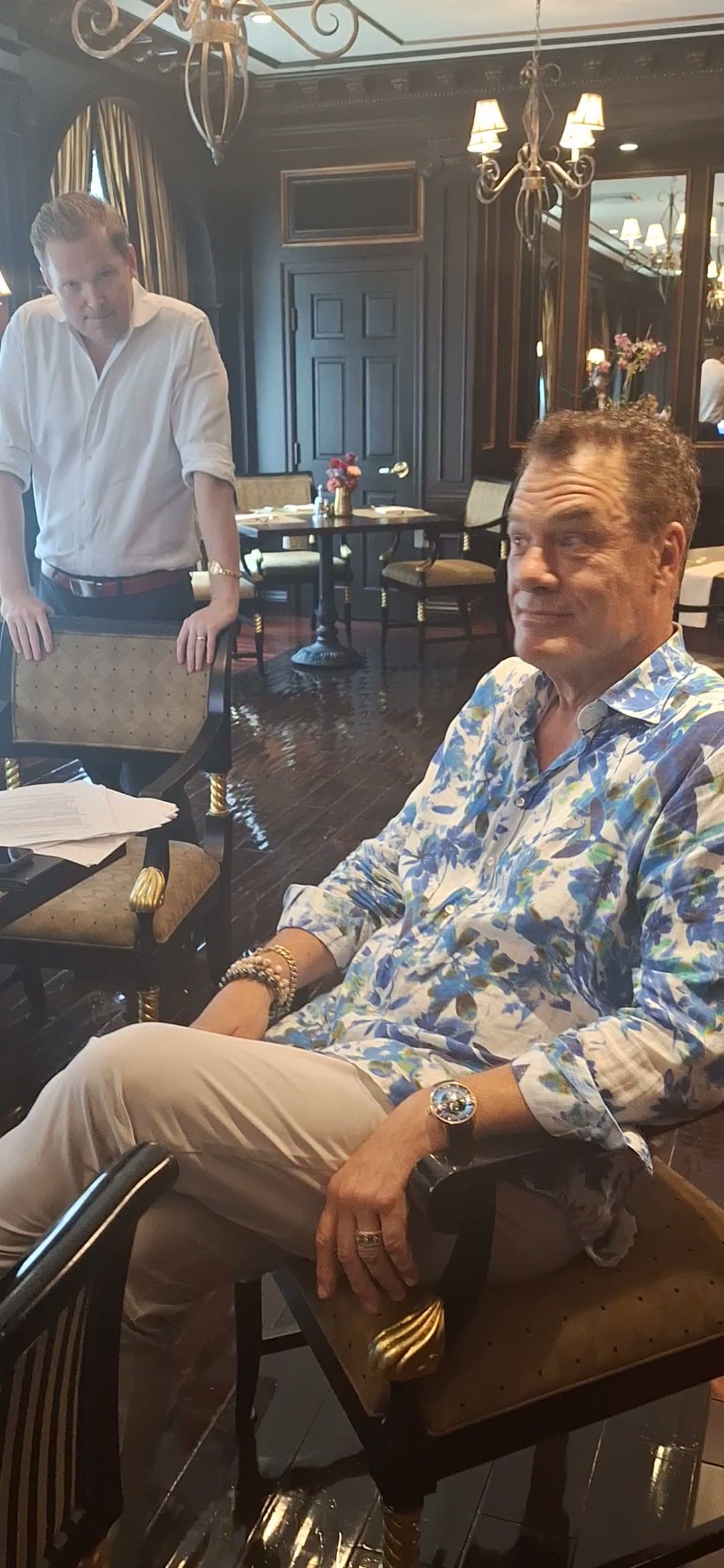 Tom relaxing with a friend in an ornate lounge