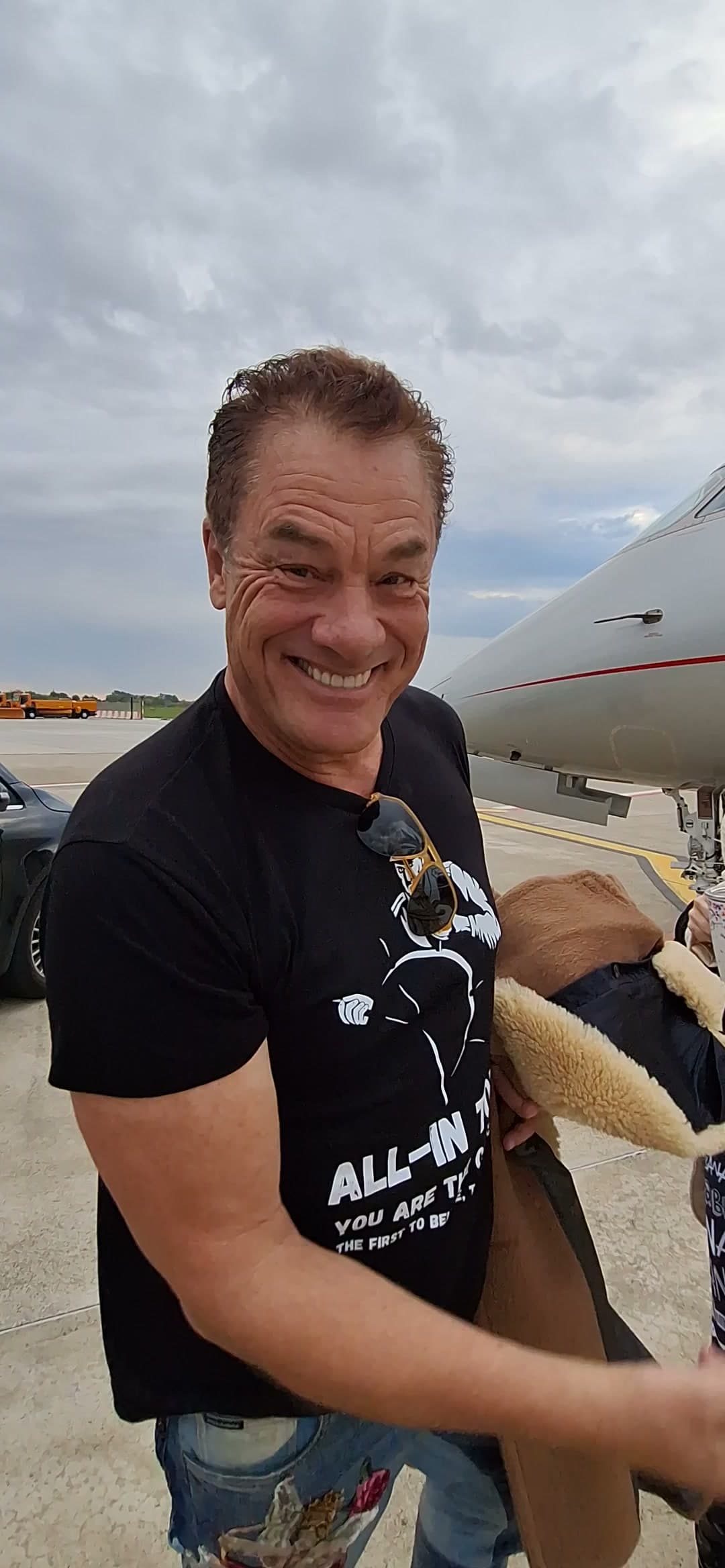 Tom grinning on the tarmac before boarding, crew behind him