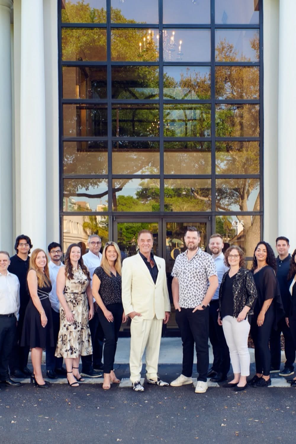 The Cummins Worldwide team gathered with Tom at the center outside the glass entrance of headquarters in Clearwater