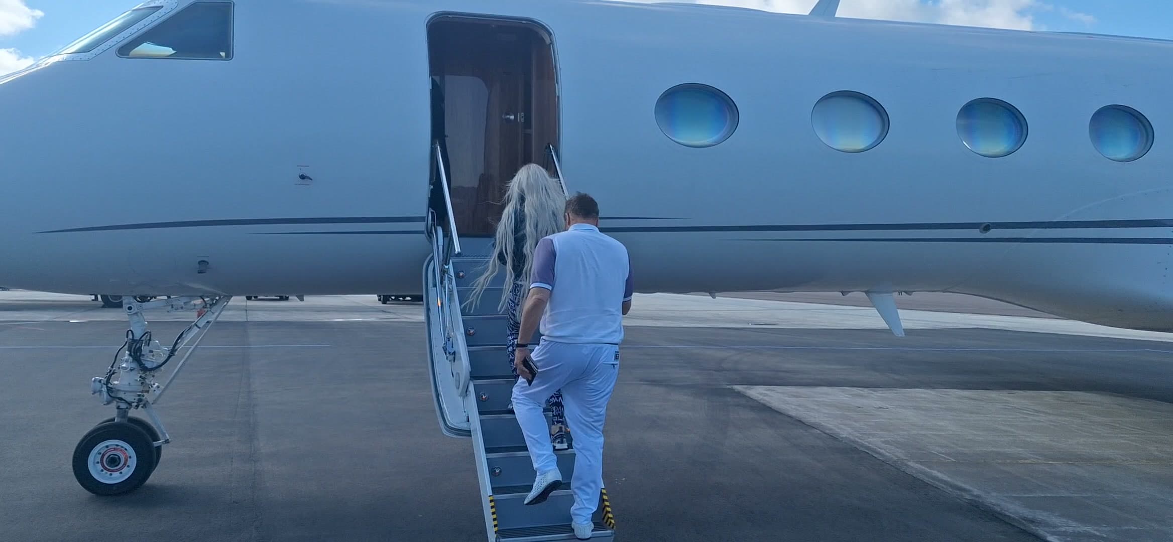 Tom and Victoria walking out to a waiting jet on the apron