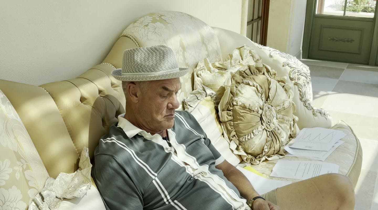 Tom reading on a brocade sofa in the sunroom at La Bella Casa