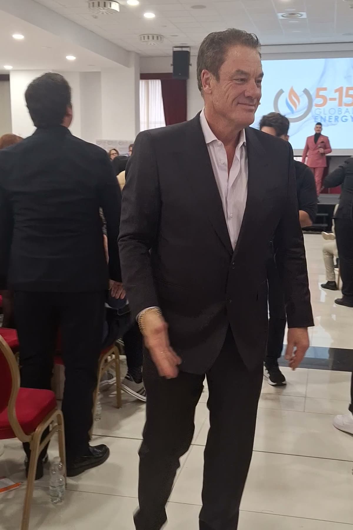 Tom Cummins walking the center aisle of a packed energy convention to applause