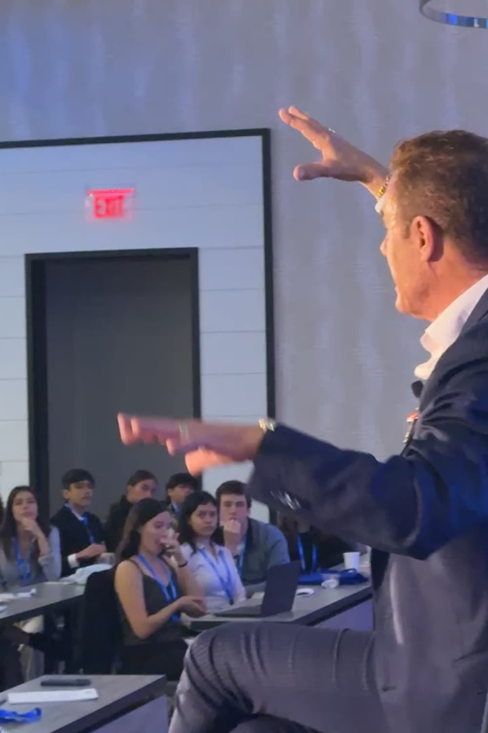 Tom Cummins commanding a packed TigerCon room, both arms out over the audience
