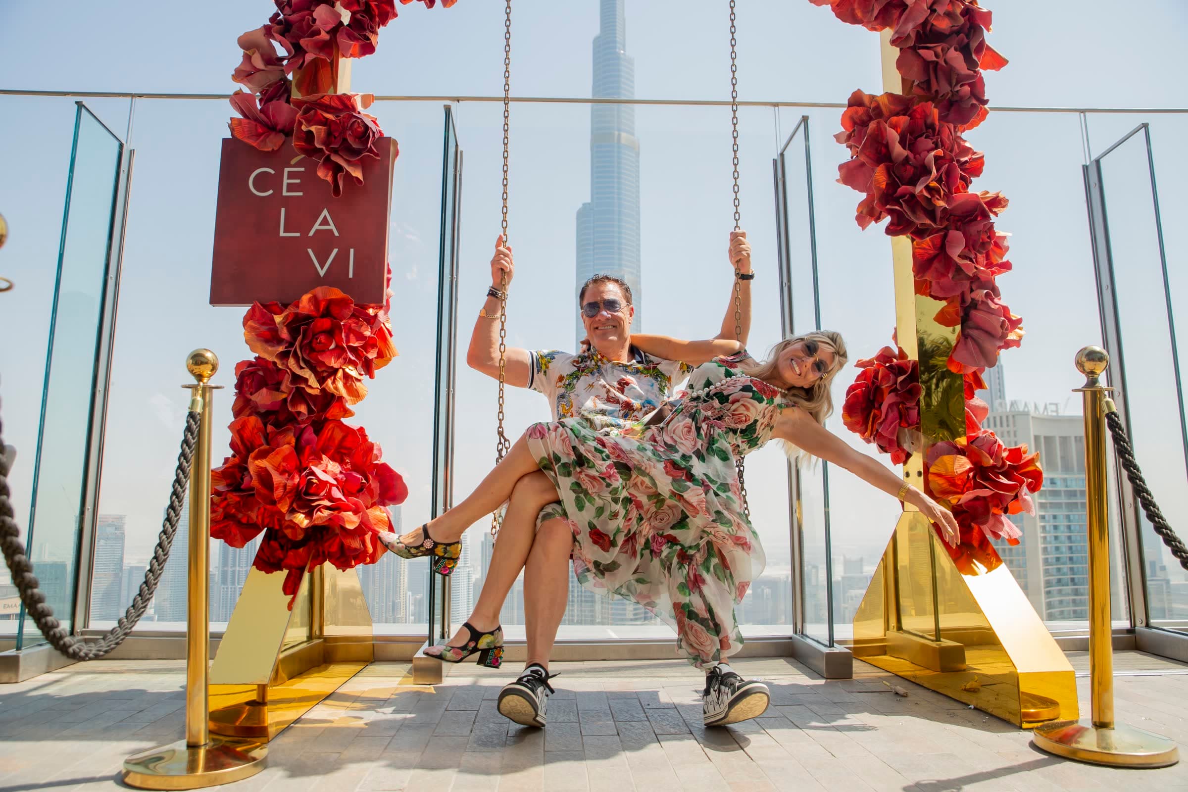 Tom and Victoria on the flower-covered swing with the Burj Khalifa behind them